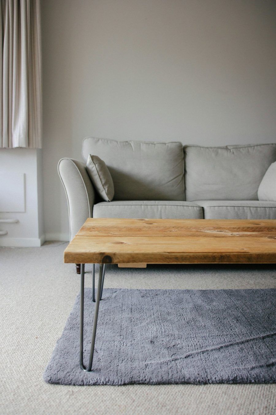 Living room with sofa, wooden coffee table and grey rug
